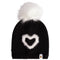 A black knit beanie hat featuring a fluffy white faux-fur pom-pom on top and a white heart-shaped knit motif on the front. A small white fabric tag with a gold star logo is visible on the lower right edge.