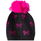 A black knit beanie hat featuring a large, fluffy hot pink pom-pom on top and multiple hot pink bow patterns embellished with rhinestones across the front.