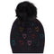 A black knit pom-pom beanie featuring a pattern of small, colorful glittery hearts in various shades, set against a plain white background.