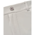 Close-up detail of light beige shorts showing the waistband, belt loop, and a four-hole button.