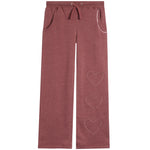 A pair of heathered dusty rose sweatpants featuring three outlined heart graphics on the lower right leg, a drawstring waist, and side pockets, shown against a plain white background.