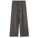 A pair of wide-leg sweatpants in a washed charcoal gray color, featuring an elastic waistband with a drawstring and side pockets, shown against a plain white background.
