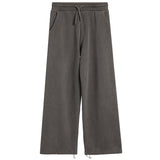 A pair of wide-leg sweatpants in a washed charcoal gray color, featuring an elastic waistband with a drawstring and side pockets, shown against a plain white background.