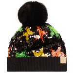 A black beanie hat with a large black faux fur pom-pom. Features sequins that reveal a multicolor star pattern of green, yellow, orange, and white.