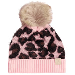 A pink knit beanie with a leopard print pattern, featuring a fluffy beige faux fur pom-pom on top and a ribbed pink brim with a small beige tag.