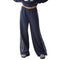 A person wearing loose navy wide-leg sweatpants with lace side stripes shown against a plain white studio background.