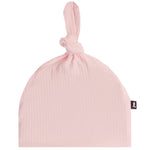 A light pink crinkle gauze baby beanie hat with a knotted top and a small black brand tag on the side, shown against a plain white background.