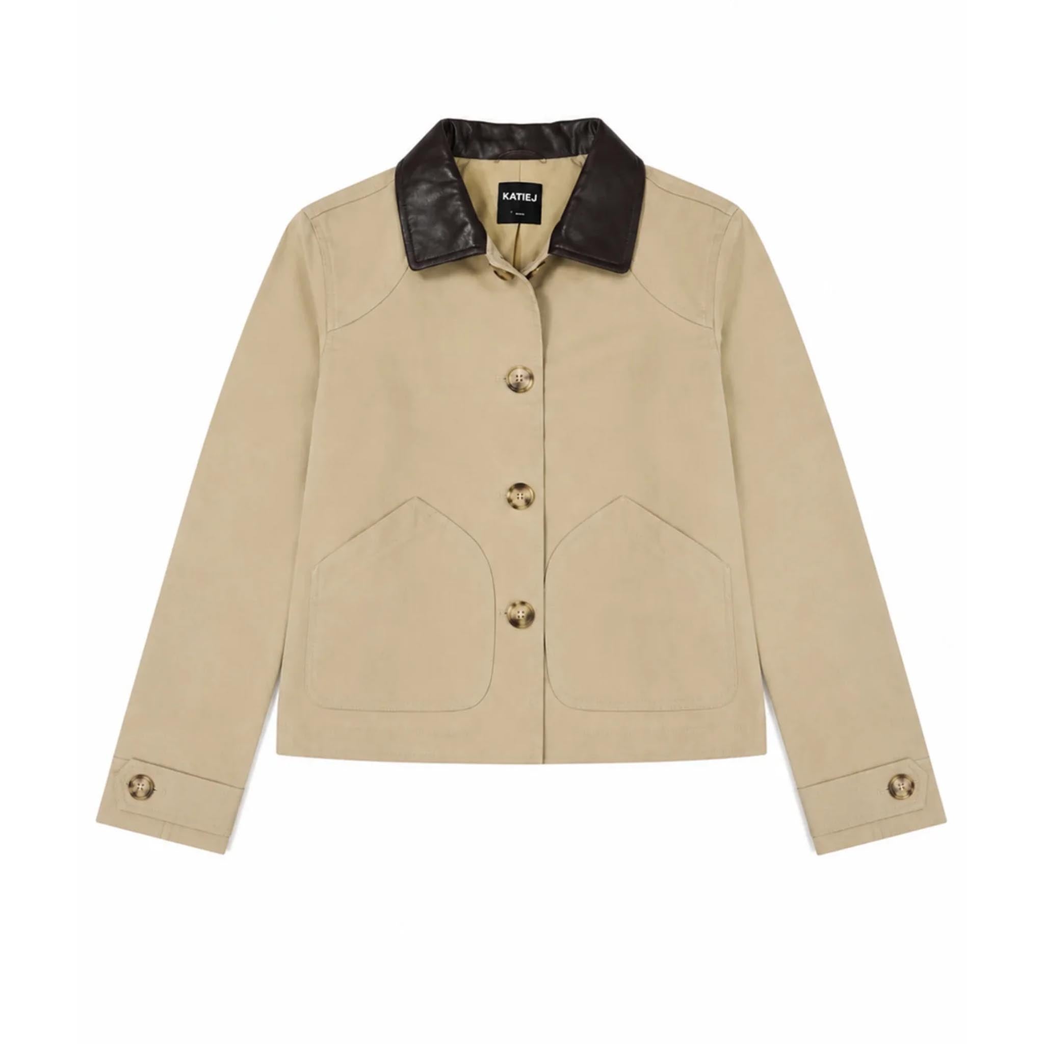 A beige cropped jacket with a dark brown leather collar, featuring three front buttons and two large front patch pockets, shown flat on a white background.