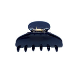 A glossy dark navy blue claw hair clip shown from the front against a plain white background.