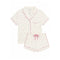 A two-piece pajama set featuring a short-sleeve button-front top and matching shorts in an off-white base with a small pink and blue ballerina print, finished with pink piping and a pink drawstring.