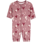 A baby short-sleeve footless one-piece romper in dusty rose pink, featuring an all-over pattern of hearts in dark red, light pink, and off-white. The romper has a front zipper closure and elastic cuffs at the ankles, shown against a plain white background.
