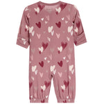 A dusty rose pink baby jumpsuit with an all-over heart pattern in shades of red, pink, and white. The jumpsuit features long sleeves with rolled cuffs, elasticated ankles, and a small 'bopppp' brand logo printed inside the collar.
