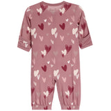 A dusty rose pink baby jumpsuit with an all-over heart pattern in shades of red, pink, and white. The jumpsuit features long sleeves with rolled cuffs, elasticated ankles, and a small 'bopppp' brand logo printed inside the collar.
