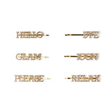 Six gold-tone letter hair clips with rhinestone lettering, arranged in two columns of three on a plain white background. The words read HELLO, BYE, GLAM, ICON, PLEASE, and RELAX.