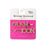 Olivia Moss Message Recieved Hair Pins set, featuring two gold bobby pins with rhinestone-embellished letters spelling 'GLAM' and 'ICON' on a pink and white retail card.