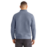 A man viewed from the back wearing a textured, ribbed knit mock-neck sweater in a dusty slate blue color against a plain white background.