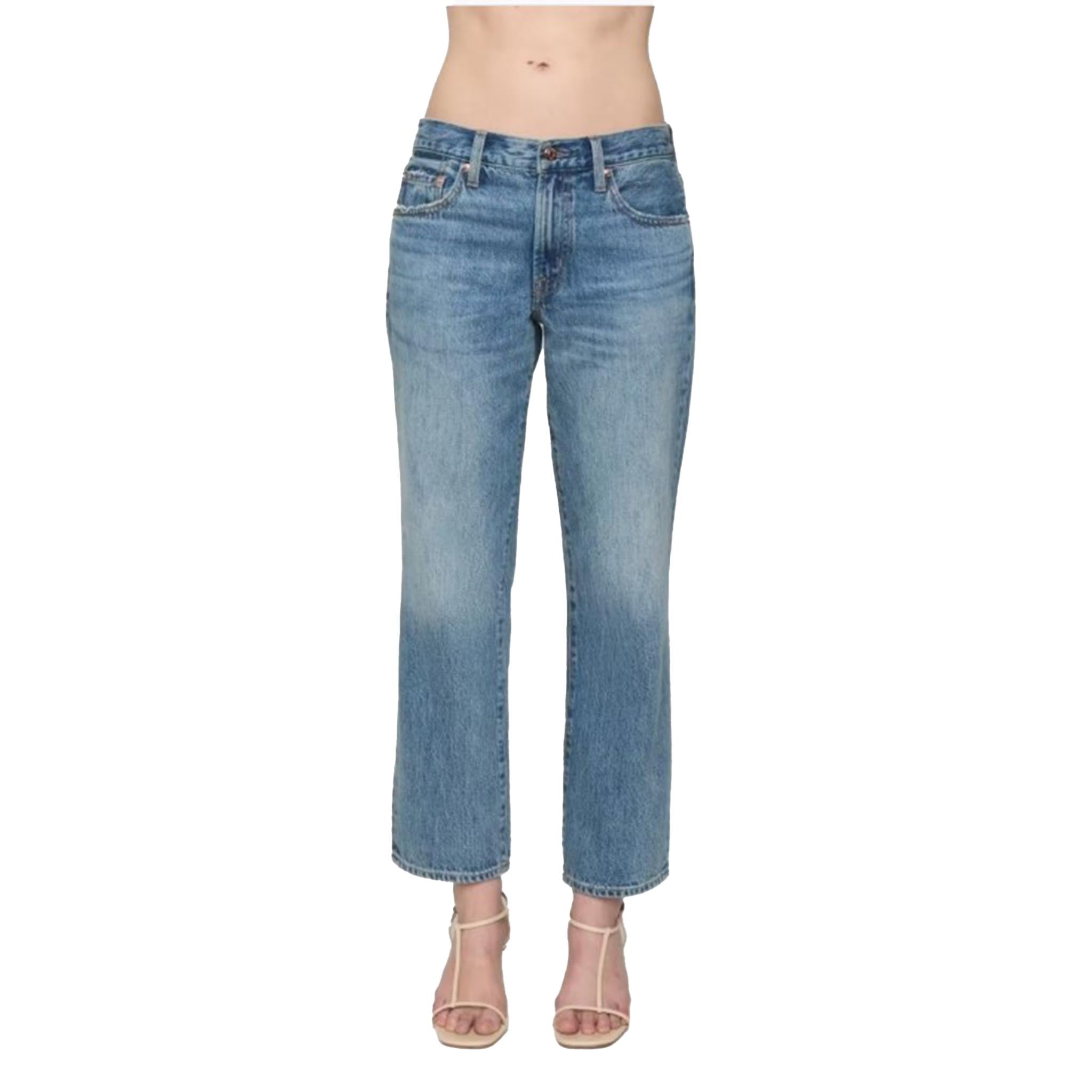 A model from the waist down wearing light blue cropped denim jeans and beige strappy high-heeled sandals, set against a plain white background.
