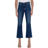 A model wearing a pair of dark blue cropped flare jeans with a white top and beige strappy heels, shown against a plain white background.