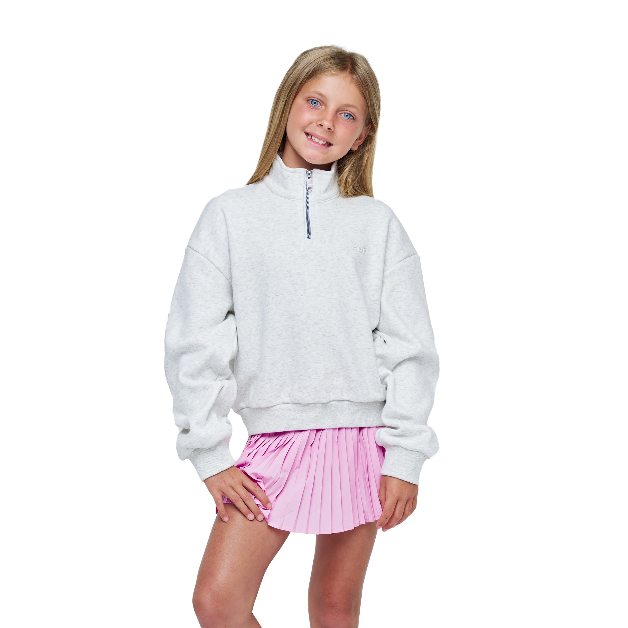 A young girl with blonde hair is modeling a light gray heathered quarter-zip sweatshirt and a pink pleated skirt against a solid white background.