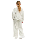 A woman viewed from behind wearing a matching light heather gray sweatshirt and wide-leg sweatpants set, paired with white sneakers, against a plain white background.
