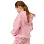 A child wearing a light pink hooded sweatshirt and matching sweatpants, shown from the back against a plain white background.