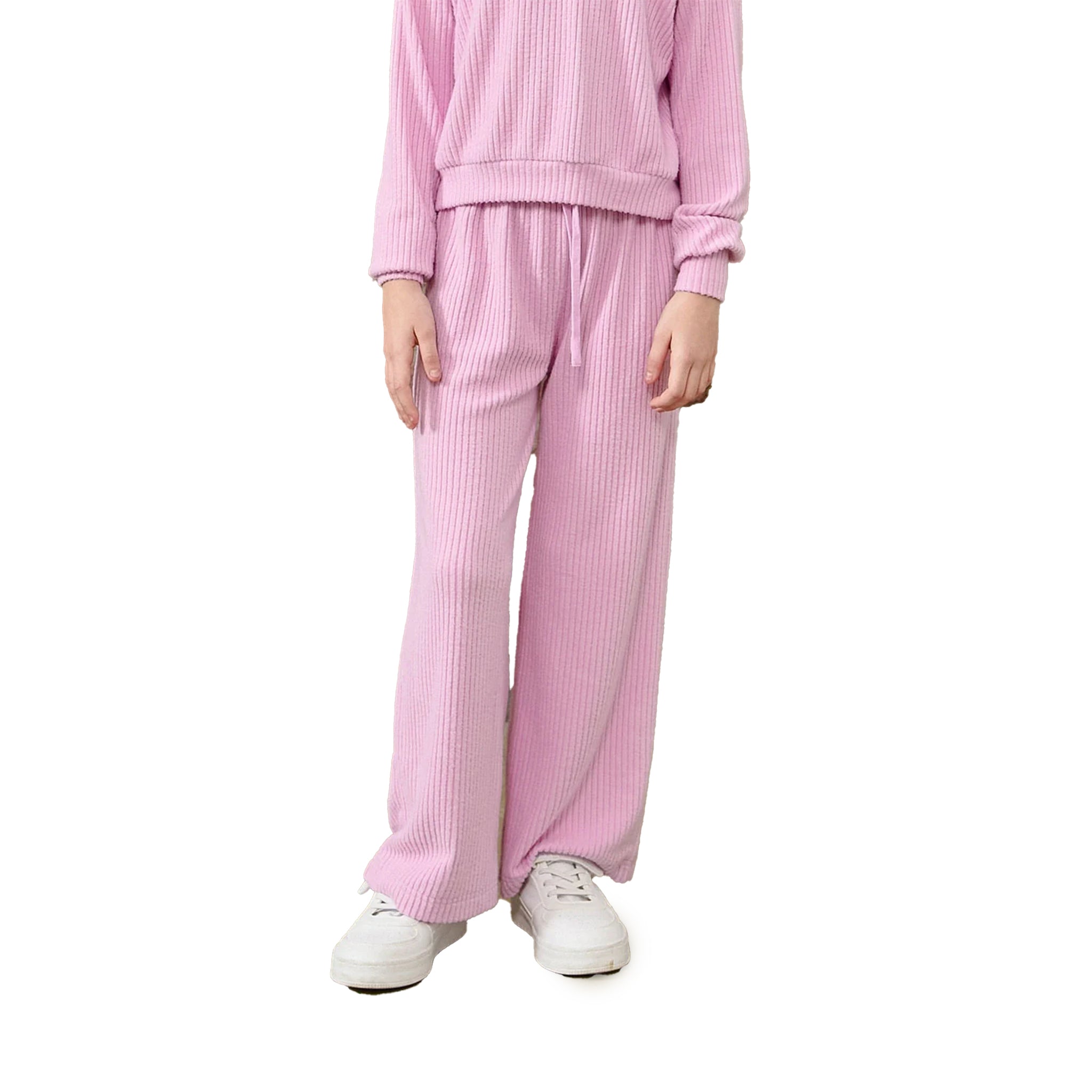 A person wearing a pink ribbed lounge set with a matching long-sleeve top and wide-leg pants, paired with white sneakers, shown against a plain white background.