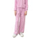 A person wearing a pink ribbed lounge set with a matching long-sleeve top and wide-leg pants, paired with white sneakers, shown against a plain white background.