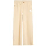 A pair of light beige ribbed knit pants with a drawstring waist and a small white brand patch on the left thigh, shown against a plain white background.