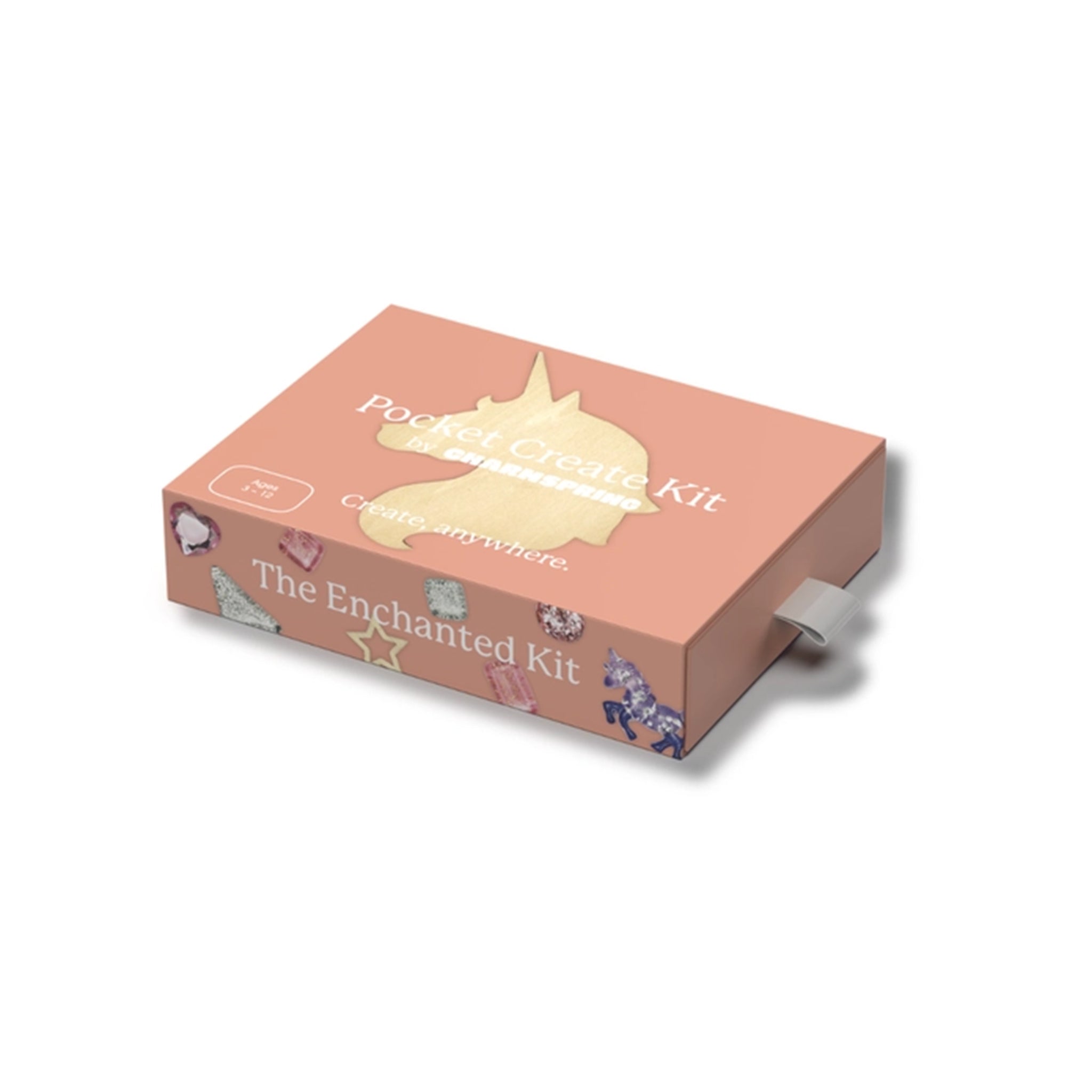 A peach-colored rectangular box labeled 'Pocket Create Kit' and 'The Enchanted Kit' with a gold unicorn silhouette on top, shown at an angle on a white background.