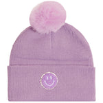 A light purple ribbed knit beanie with a fluffy matching pom-pom on top and a circular embroidered smiley face patch on the front cuff.