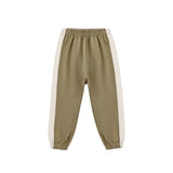 A pair of children's jogger pants in a muted khaki green, featuring cream-colored side panels and elastic cuffs, shown against a plain white background.