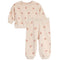 A two-piece children's pajama set featuring a long-sleeve top and matching pants in a light cream color with a small red bow print, displayed on a solid white background.