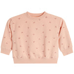 A light peach-pink long-sleeve baby's crewneck sweatshirt with a repeating pattern of small pink hearts, shown flat against a white background.