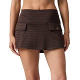 A model wearing a dark brown houndstooth mini skirt with front flap pockets and gold-tone button closures, shown from the waist to mid-thigh on a white studio background.