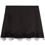 A black satin slip skirt with a delicate black lace hem, displayed flat against a solid white background.