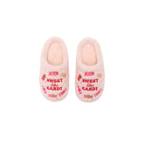 A pair of plush pink slipper shoes with 'SWEET like CANDY' embroidered in red on the front, decorated with candy illustrations in pink, red, and orange.