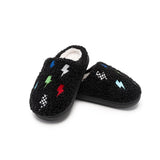 A pair of black fuzzy slip-on slippers with embroidered lightning bolts in multiple colors and small checkered patterns, shown on a plain white background.