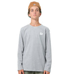 A young man wearing a light gray long-sleeve crewneck shirt with a small white stylized logo on the left chest, paired with a tan baseball cap, photographed against a solid white background.