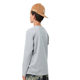 A boy from the back wearing a light gray long-sleeve t-shirt, a tan baseball cap with a white embroidered logo, and dark patterned shorts, set against a plain white background.