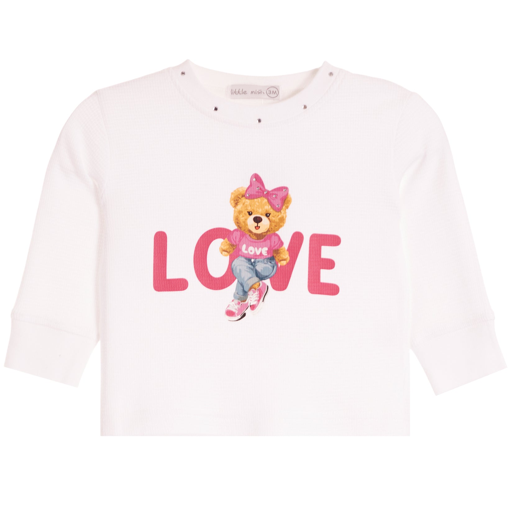 A white long-sleeve baby/toddler top featuring a central graphic of a teddy bear wearing a pink bow and jeans, sitting on the word 'LOVE' in pink letters.