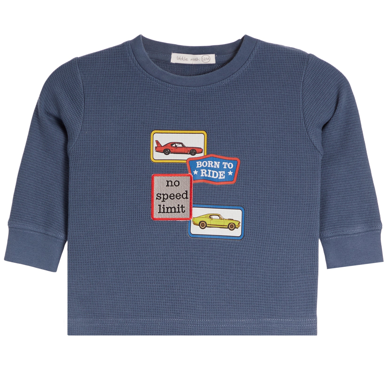 A toddler's long-sleeve waffle-knit shirt in slate blue, featuring three colorful graphic patches on the chest with cars and text reading 'BORN TO RIDE' and 'no speed limit'.