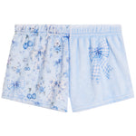 Light blue baby shorts featuring a floral print with cherries and stars on one leg and a large blue-and-white gingham bow on the other leg.