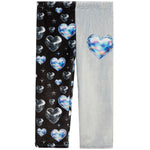 A pair of children's leggings shown flat against a white background, featuring a split design: one leg is black with a pattern of holographic hearts and stars, and the other leg is light gray with a large matching holographic heart on the upper thigh.
