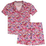 A two-piece short-sleeve pajama set with a vibrant multicolor floral print on a pink base, featuring a matching collared top and shorts.