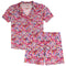 A two-piece short-sleeve pajama set with a vibrant multicolor floral print on a pink base, featuring a matching collared top and shorts.