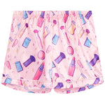 Pink pajama shorts with a colorful cosmetic-themed print featuring lipsticks, makeup brushes, sponges, and compacts, shown flat against a white background.