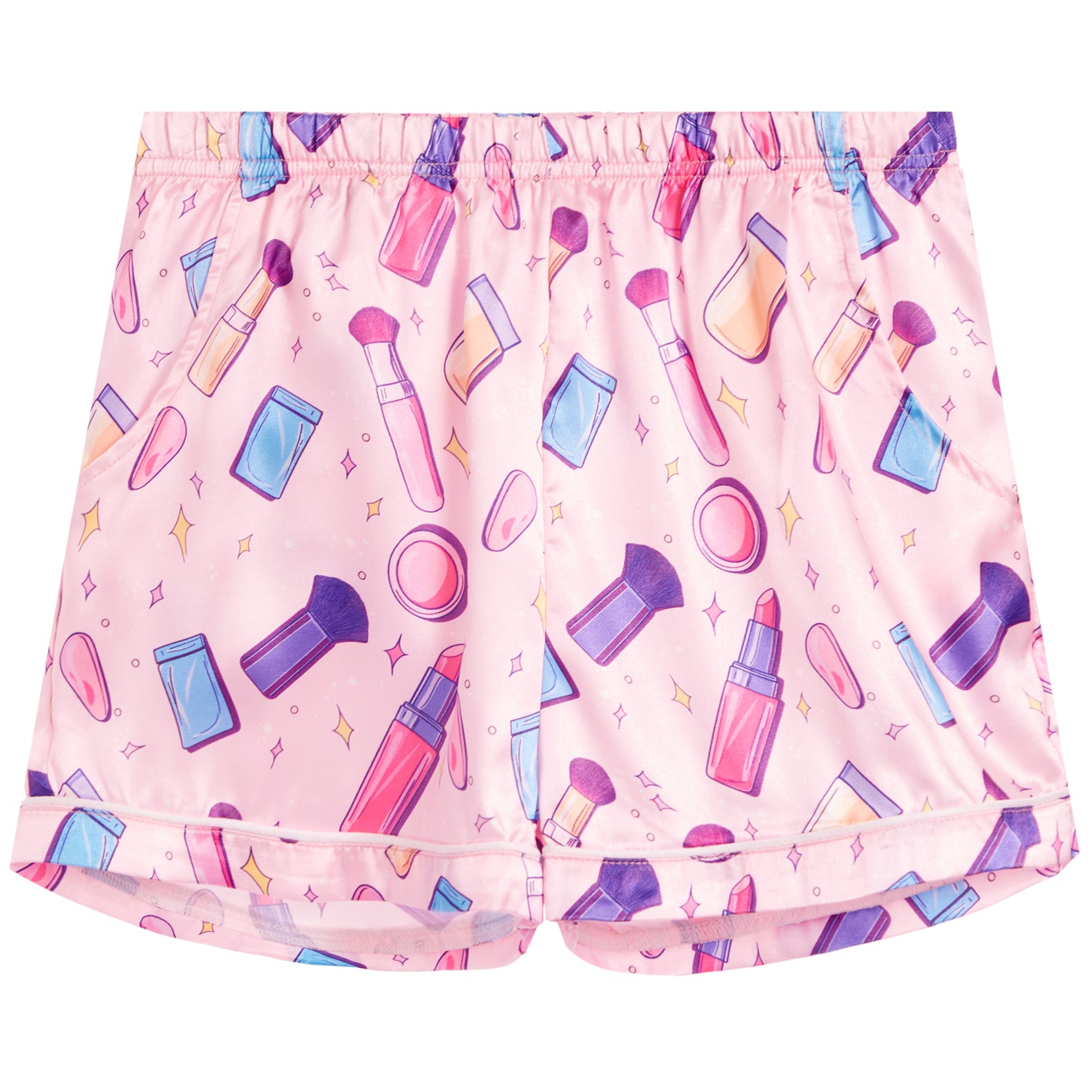 Pink pajama shorts with a colorful cosmetic-themed print featuring lipsticks, makeup brushes, sponges, and compacts, shown flat against a white background.
