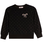 A black long-sleeve crewneck sweatshirt with a delicate pattern of small white dots across the fabric, featuring a decorative bow embellishment on the left chest in a sparkling rhinestone pattern.