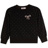A black long-sleeve crewneck sweatshirt with a delicate pattern of small white dots across the fabric, featuring a decorative bow embellishment on the left chest in a sparkling rhinestone pattern.