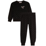 A two-piece kids' loungewear set in black, featuring a long-sleeve sweatshirt with a small bow embellishment on the chest and matching jogger pants, both decorated with tiny white polka dots.